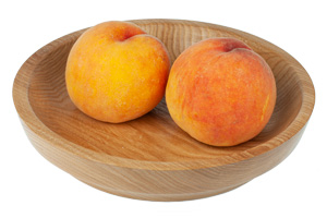 Персики на деревянной тарелке из береста